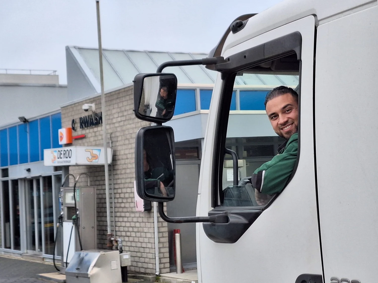 Een medewerker in de cabine van de verhuiswagen